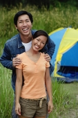 Couple looking at camera, tent in the background - Asia Images Group