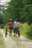 Couple walking with bicycles - Asia Images Group