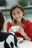 Women having coffee, one woman smiling at camera - Asia Images Group