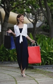 Woman walking, carrying shopping bags - Asia Images Group
