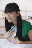 Young woman holding book, smiling - Asia Images Group
