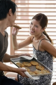 Woman feeding man a cookie - Asia Images Group