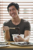 Man in kitchen with mixing bowl - Asia Images Group