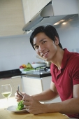 Man sitting down for a meal, smiling at camera - Asia Images Group