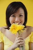 Young woman holding yellow flowers - Asia Images Group