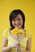 Young woman with stalks of yellow flowers - Asia Images Group
