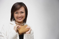 Young woman holding purse, smiling at camera - Asia Images Group