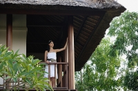 Young woman standing in balcony, looking out - Asia Images Group