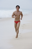 Man running along beach - Asia Images Group