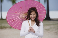 Young woman using pink umbrella - Asia Images Group