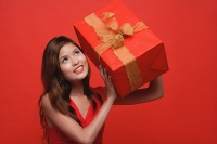 Woman in red dress, holding wrapped gift box - Asia Images Group