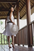 Young woman in white dress, walking and looking over shoulder - Asia Images Group
