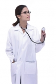 Female doctor in lab coat, holding stethoscope, looking away - Asia Images Group