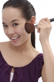 Young woman applying make-up - Asia Images Group