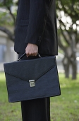 Businessman holding briefcase, side view - Asia Images Group