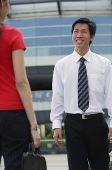 Male executive smiling at woman in front of him - Asia Images Group