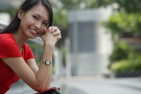Young woman smiling at camera, hands clasped - Asia Images Group