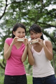 Two women eating ice cream, looking at camera - Asia Images Group
