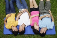Young adults in park, lying on mat - Asia Images Group