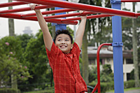 Boy using the jungle gym at playground - Asia Images Group