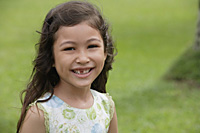 Girl with gap-toothed smile, looking at camera - Asia Images Group