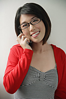 Woman with red jacket using mobile phone - Asia Images Group