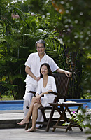 Couple outdoors by swimming pool, looking at camera, portrait - Asia Images Group