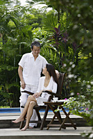 Couple outdoors in garden, looking at each other - Asia Images Group