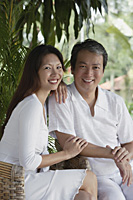 Couple sitting side by side, looking at camera - Asia Images Group