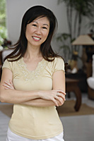 Woman with arms crossed, smiling at camera - Asia Images Group