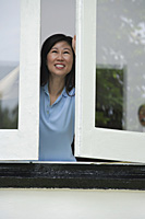Woman opening windows, smiling - Asia Images Group