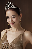 portrait of woman wearing crown, smiling at camera - Asia Images Group