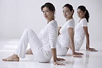three women sitting on floor, side view, looking at camera - Asia Images Group