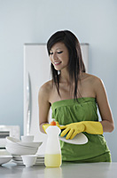 woman in kitchen, washing dishes, cleaning - Asia Images Group
