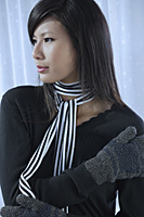 woman wearing scarf and mittens, looking away from camera - Asia Images Group