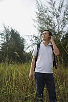 Man talking on mobile phone, hiking, outdoors - Asia Images Group