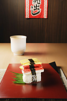 4 pieces of sushi, kanikama and tamago nigiri, "for sale" sign - Asia Images Group
