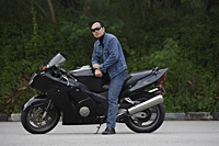 Mature man sitting on motorcycle, wearing sunglasses - Asia Images Group
