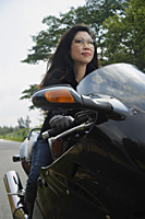 Mature woman riding motorcycle, wearing sunglasses - Asia Images Group