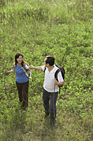 Man and woman hiking outdoors, nature, holding hands - Asia Images Group