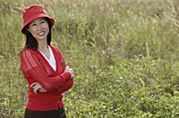 woman standing outdoors in nature, smiling at camera - Asia Images Group