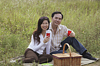 Man and woman having picnic outdoors in nature - Asia Images Group