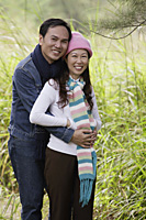 Man and woman wearing hat and scarves, standing outdoors in nature - Asia Images Group