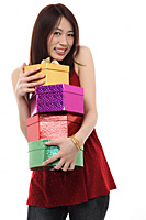 Young woman holding four presents, smiling at camera - Asia Images Group