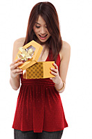 Young woman opening present and looking inside box - Asia Images Group
