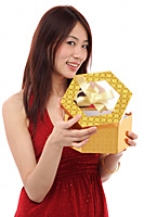 Young woman opening present, and looking at camera - Asia Images Group