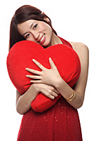 Young woman hugging red heart shaped pillow - Asia Images Group