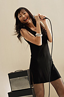 Young woman singing into microphone, rock star - Asia Images Group