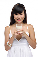 Young woman holding glass of milk, smiling - Asia Images Group