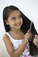 A young girl combs her hair - Asia Images Group